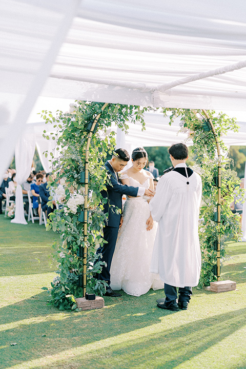  navy and white garden wedding with the groom in a navy suit and the bride in a white ballgown – ceremony 