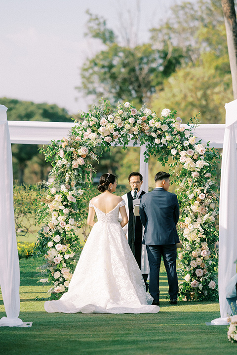  navy and white garden wedding with the groom in a navy suit and the bride in a white ballgown - ceremony