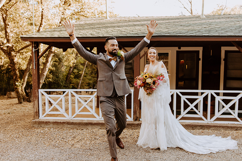  rustic bohemian wedding with brown and gold color scheme – couple cheering 