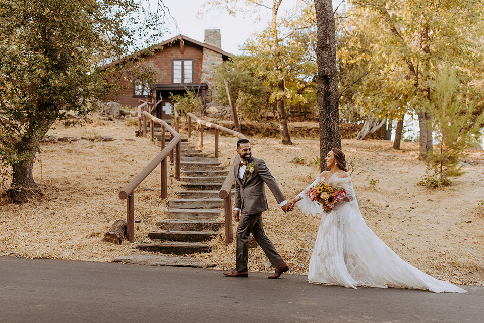  rustic bohemian wedding with brown and gold color scheme – couple walking uphill 