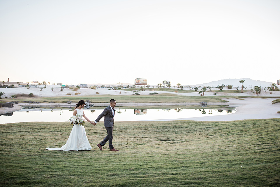  bride in a European inspired gown with lace details, a high neckline, and long sleeves and the groom in a black tuxedo and a black bow tie 