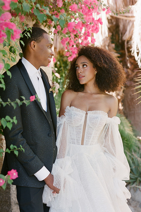  romantic wedding at colony 29 with the bride in a tulle ballgown with sleeves and the groom in a diamond black tuxedo – couple in the garden  