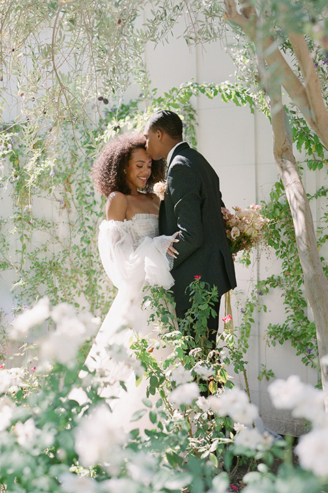  romantic wedding at colony 29 with the bride in a tulle ballgown with sleeves and the groom in a diamond black tuxedo – couple in the garden   