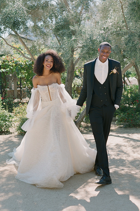  romantic wedding at colony 29 with the bride in a tulle ballgown with sleeves and the groom in a diamond black tuxedo – couple in the garden   