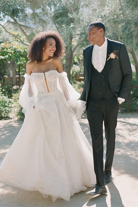  romantic wedding at colony 29 with the bride in a tulle ballgown with sleeves and the groom in a diamond black tuxedo – couple in the garden  