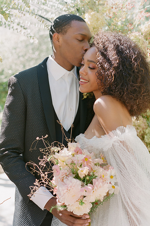  romantic wedding at colony 29 with the bride in a tulle ballgown with sleeves and the groom in a diamond black tuxedo – couple in the garden   