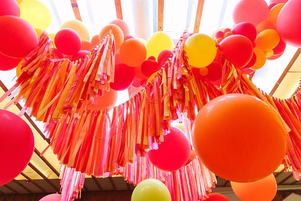  a colorful disco wedding in dtla with the bride in a champagne gown with metallic stars and the groom in a cobalt blue suit – streamers and balloon decor