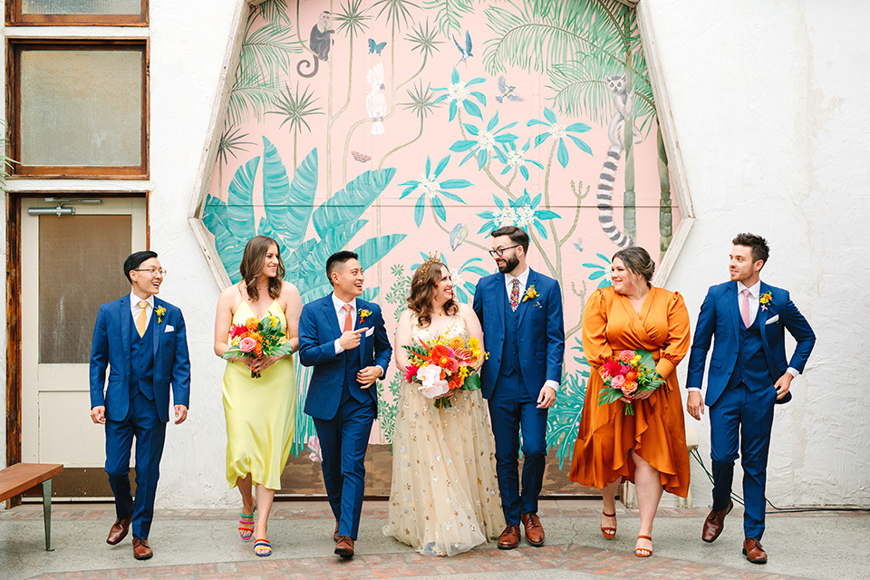  a colorful disco wedding in dtla with the bride in a champagne gown with metallic stars and the groom in a cobalt blue suit –bridal party walking
