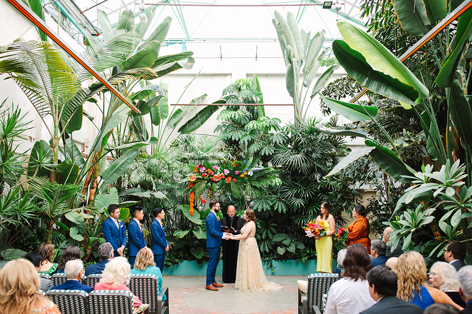  a colorful disco wedding in dtla with the bride in a champagne gown with metallic stars and the groom in a cobalt blue suit – couple at the ceremony
