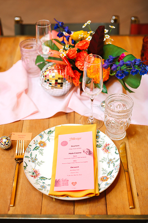  a colorful disco wedding in dtla with the bride in a champagne gown with metallic stars and the groom in a cobalt blue suit – flatware decor 