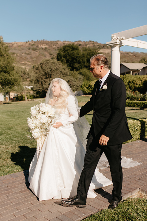  black and white wedding design with luxe details – bride walking down the aisle