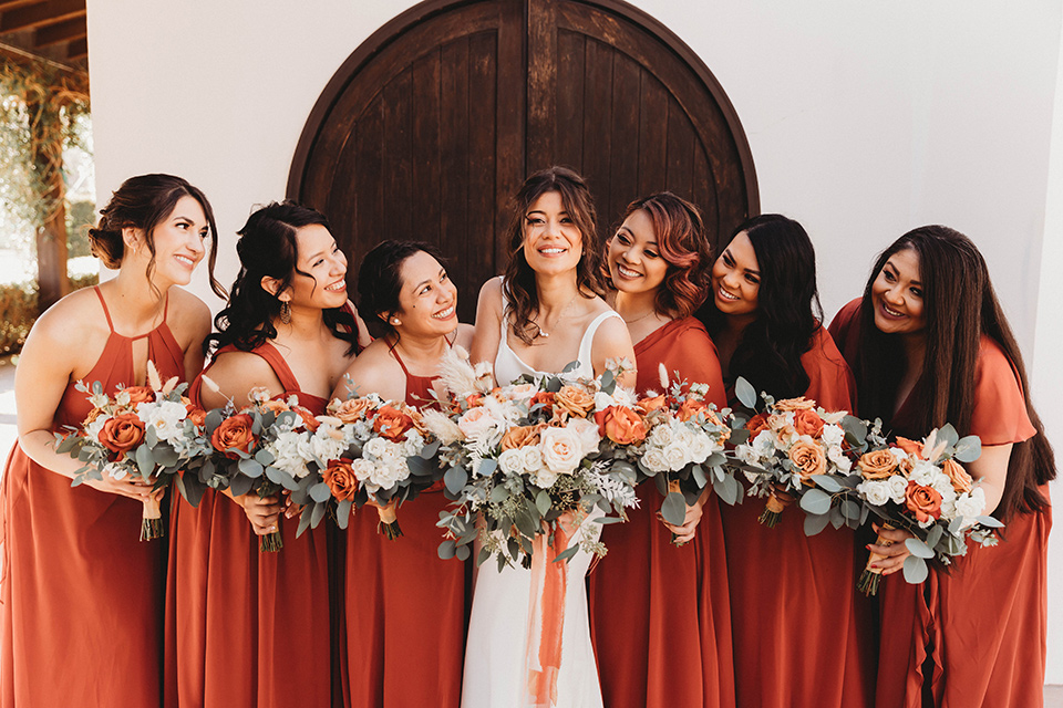  a fall toned wedding at the Fallbrook Estate Wedgewood venue with the groom and groomsmen in grey suits and the bridesmaids in orange – bridesmaids 