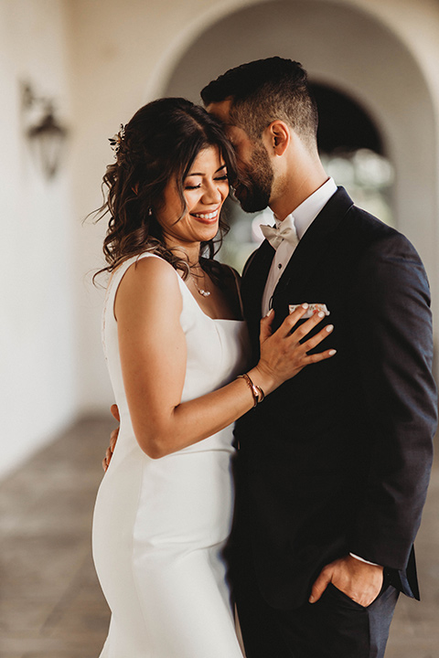  a fall toned wedding at the Fallbrook Estate Wedgewood venue with the groom and groomsmen in grey suits and the bridesmaids in orange – couple hugging