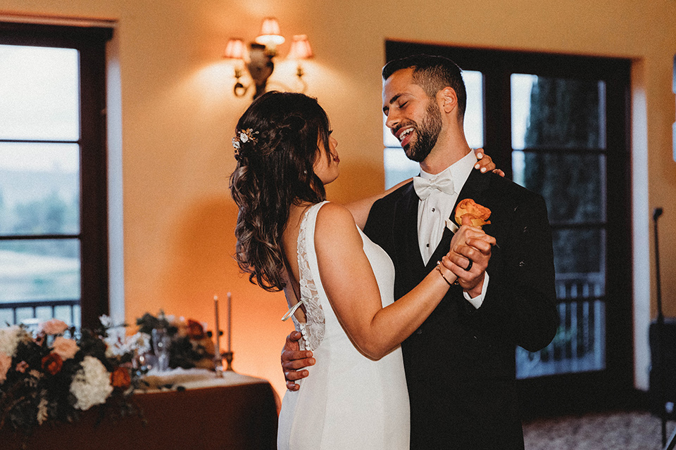  a fall toned wedding at the Fallbrook Estate Wedgewood venue with the groom and groomsmen in grey suits and the bridesmaids in orange – couple’s first dance 
