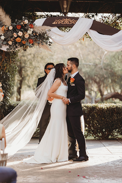  a fall toned wedding at the Fallbrook Estate Wedgewood venue with the groom and groomsmen in grey suits and the bridesmaids in orange – couple at the ceremony 
