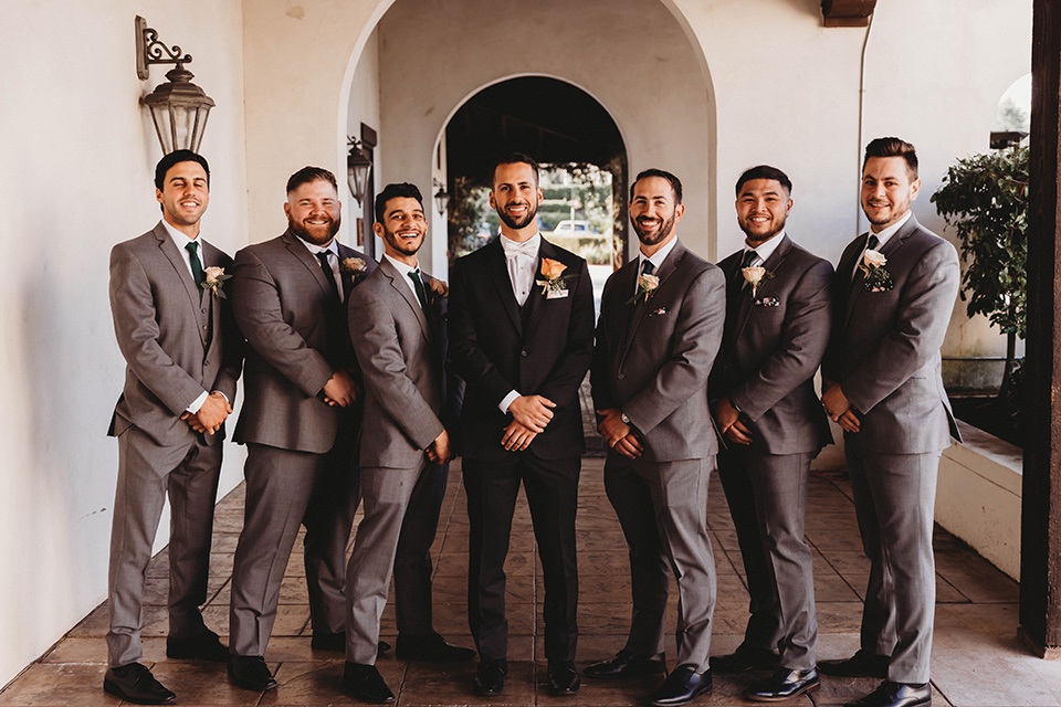  a fall toned wedding at the Fallbrook Estate Wedgewood venue with the groom and groomsmen in grey suits and the bridesmaids in orange – groomsmen in a line 