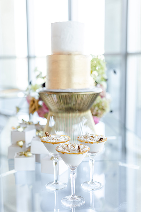 Modern romantic city wedding with an all-white color scheme and bright florals – one bride wore a strapless a-line gown and the other bride wore a white suit – gold and white with florals cake