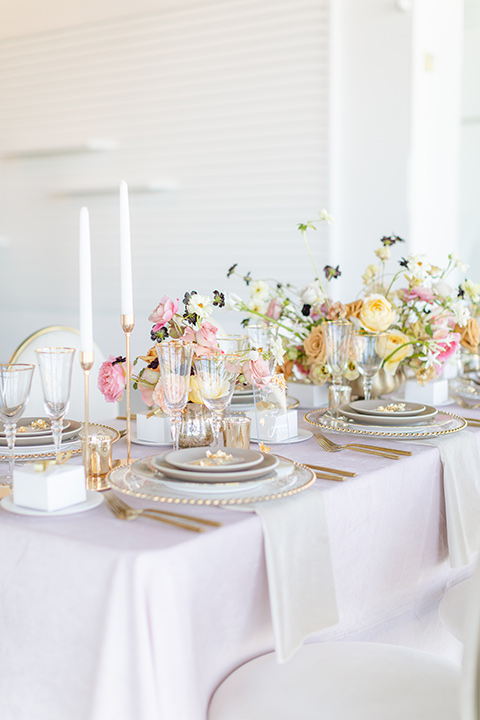 Modern romantic city wedding with an all-white color scheme and bright florals – one bride wore a strapless a-line gown and the other bride wore a white suit – table decor 