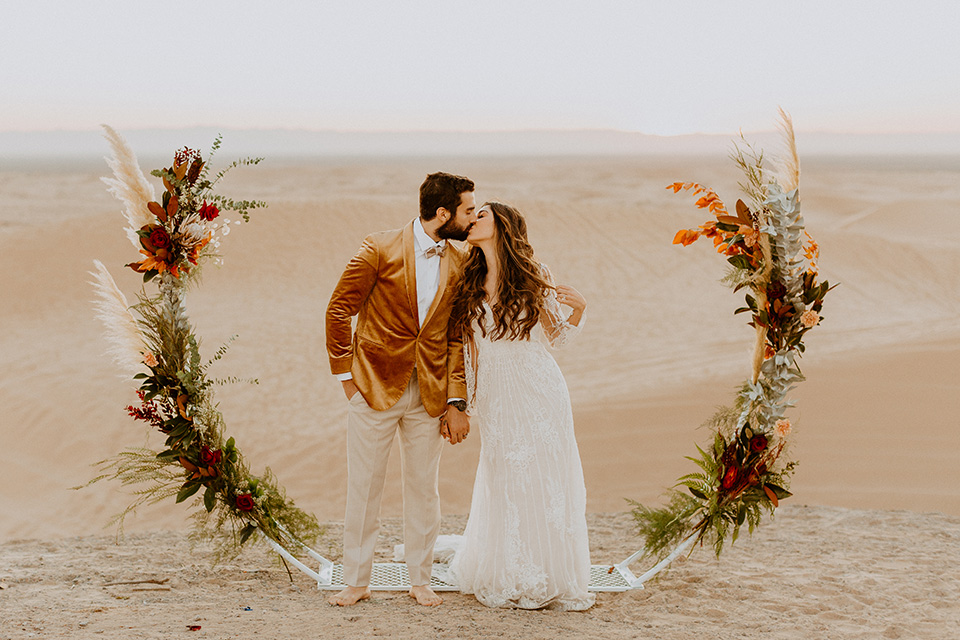  glamis sand dunes wedding with the groom in a tan and a gold velvet tuxedo at sunset – couple at ceremony