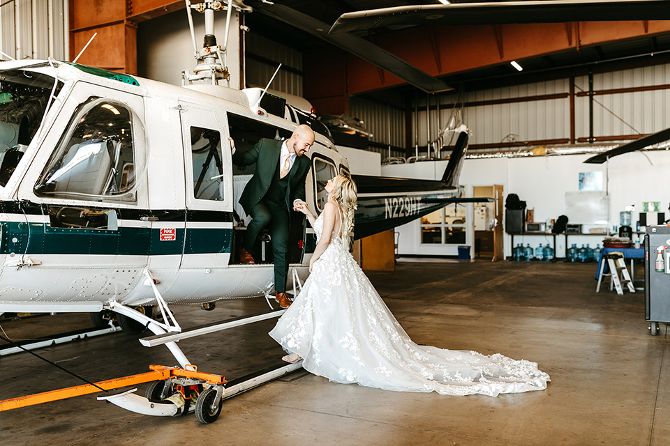  tropical metallic wedding with the bride in an ivory lace gown and the groom in a green suit 