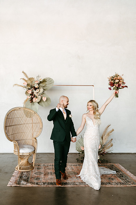  tropical metallic wedding with the bride in an ivory lace gown and the groom in a green suit 