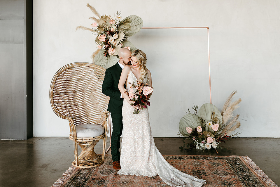  tropical metallic wedding with the bride in an ivory lace gown and the groom in a green suit 