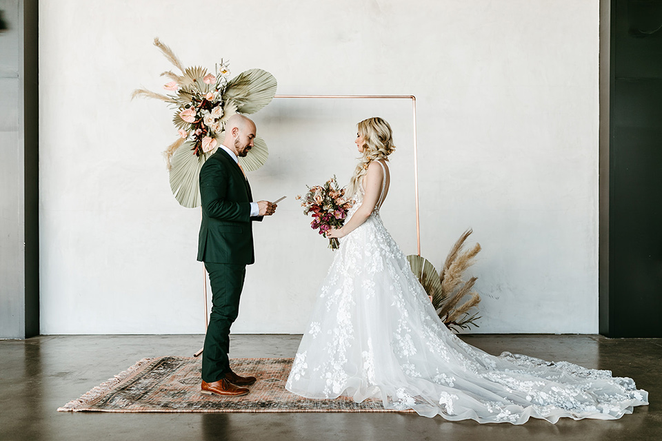  tropical metallic wedding with the bride in an ivory lace gown and the groom in a green suit 