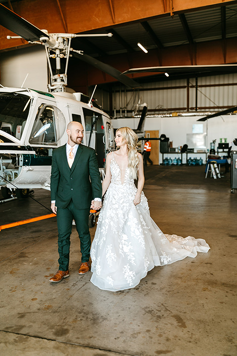  tropical metallic wedding with the bride in an ivory lace gown and the groom in a green suit 