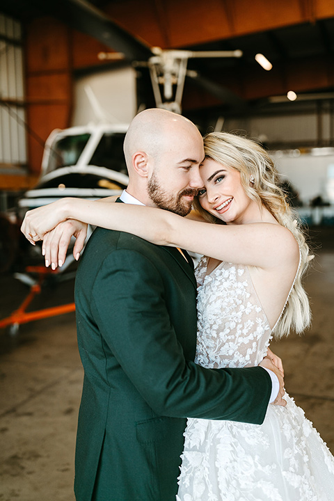  tropical metallic wedding with the bride in an ivory lace gown and the groom in a green suit 