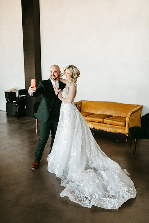  tropical metallic wedding with the bride in an ivory lace gown and the groom in a green suit 