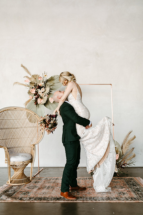 tropical metallic wedding with the bride in an ivory lace gown and the groom in a green suit 