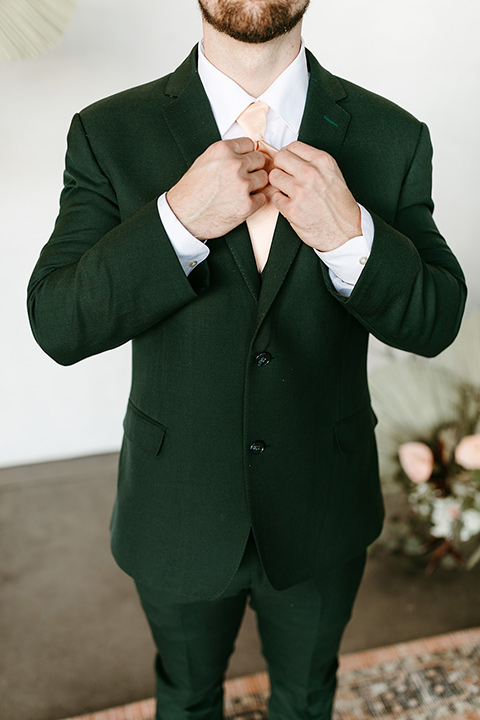  tropical metallic wedding with the bride in an ivory lace gown and the groom in a green suit 