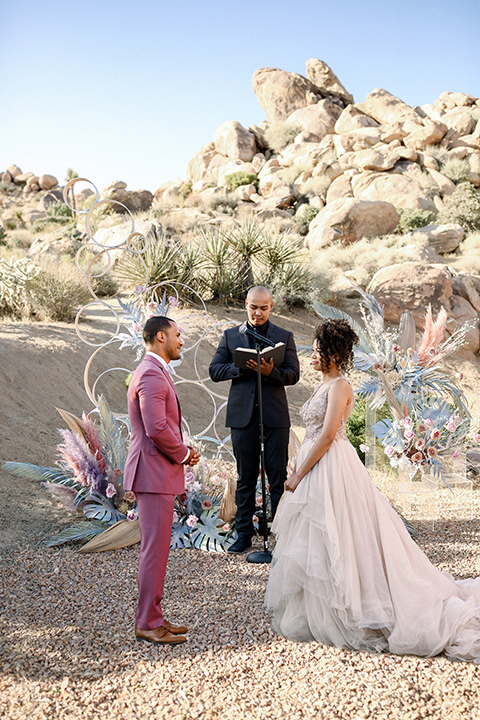  Iridescent dreams in the desert with the bride in a pink dress and the groom in a rose suit - ceremony