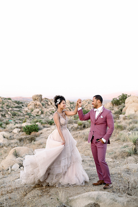  Iridescent dreams in the desert with the bride in a pink dress and the groom in a rose suit – couple dancing
