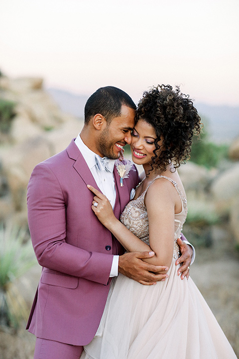  Iridescent dreams in the desert with the bride in a pink dress and the groom in a rose suit – couple close 