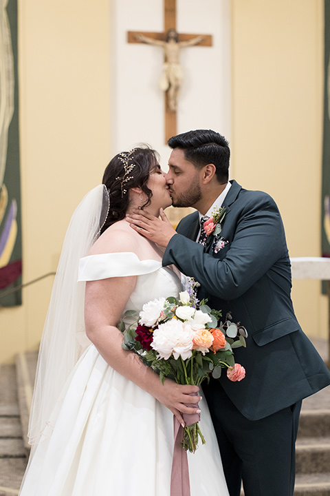  garden wedding with a green and pink color scheme – bride and groom first kiss 