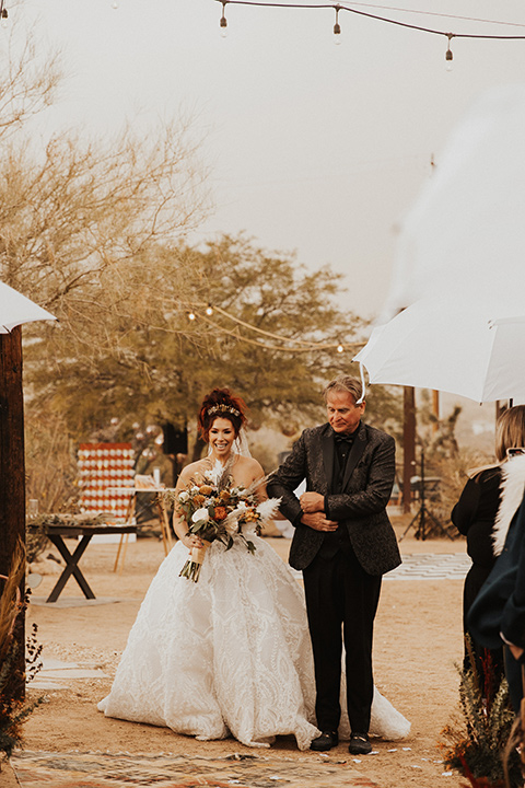  Jillian Rose Reed’s fabulous desert boho wedding – bride in her white ball gown with her dad walking down the aisle
