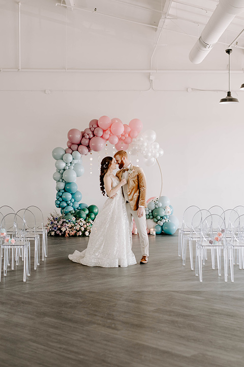  pastel and gold wedding with celestial décor – and the groom in a tan suit and a gold velvet tuxedo – couple at ceremony 