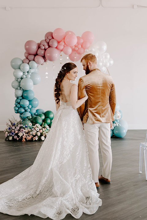  pastel and gold wedding with celestial décor – and the groom in a tan suit and a gold velvet tuxedo – couple at ceremony 