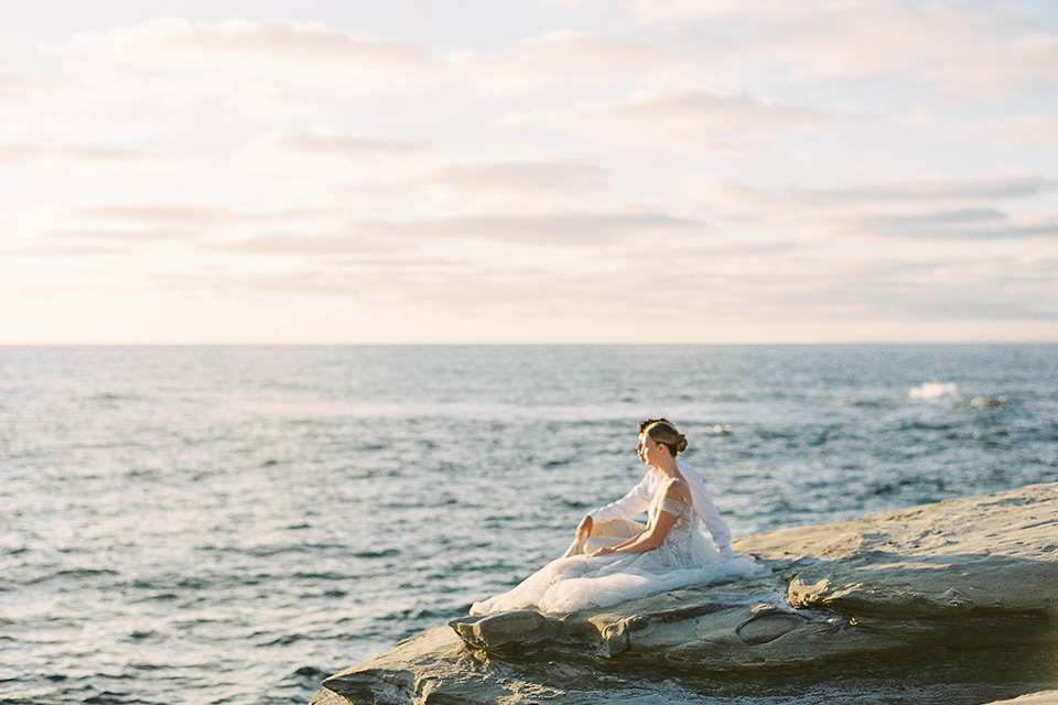  la jolla wedding on the beach with the groom in a tan suit – couple sitting