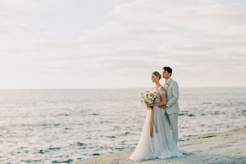  la jolla wedding on the beach with the groom in a tan suit – couple sitting