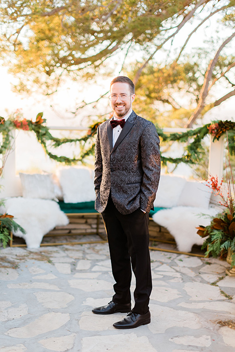  romantic winter inspired wedding theme with luxe textures and details, one groom wore a burgundy velvet shawl tuxedo and the other groom in a black paisley tuxedo – groom in a black paisley tuxedo 