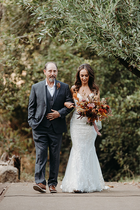  boho autumn wedding with the groom and groomsmen in a green suit – bride walking down the aisle