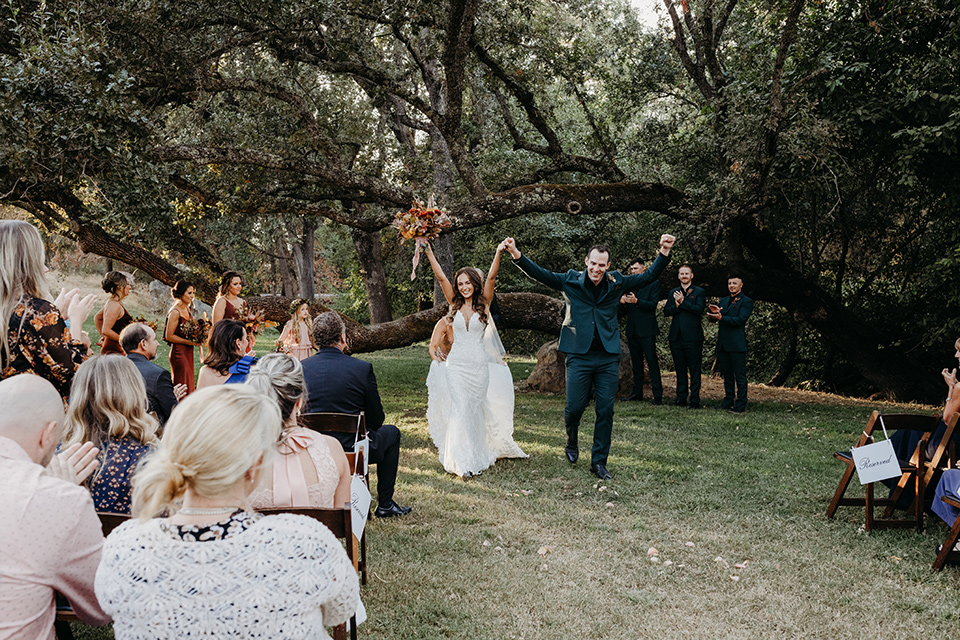 boho autumn wedding with the groom and groomsmen in a green suit –walking down the aisle