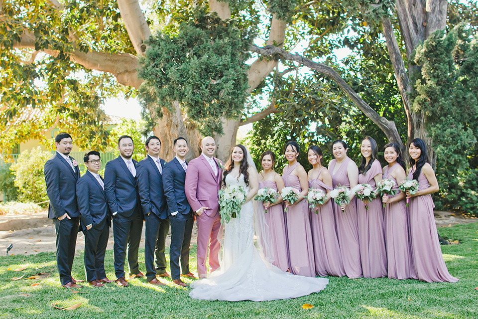  garden wedding at rancho los Cerritos with the groom in a rose pink suit and the groomsmen in navy suits 