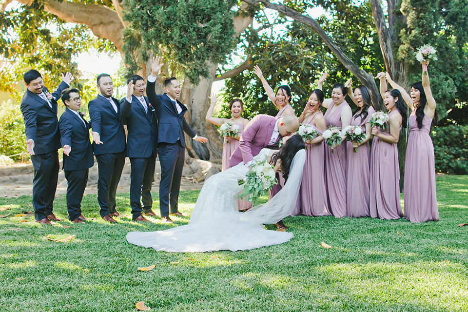  garden wedding at rancho los Cerritos with the groom in a rose pink suit and the groomsmen in navy suits 