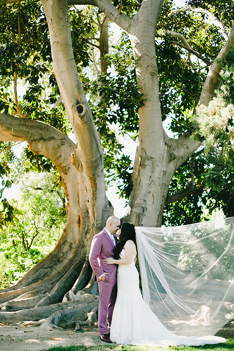  garden wedding at rancho los Cerritos with the groom in a rose pink suit and the groomsmen in navy suits 