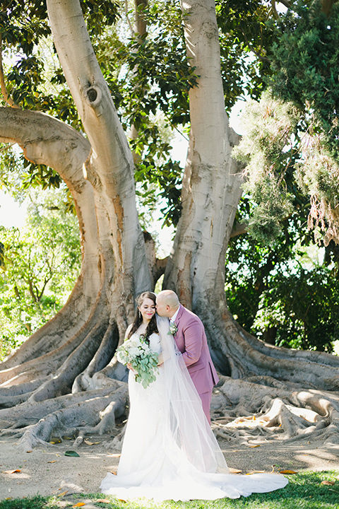  garden wedding at rancho los Cerritos with the groom in a rose pink suit and the groomsmen in navy suits 