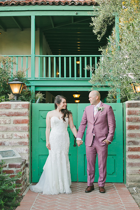  garden wedding at rancho los Cerritos with the groom in a rose pink suit and the groomsmen in navy suits 