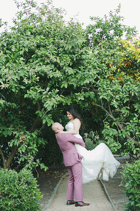  garden wedding at rancho los Cerritos with the groom in a rose pink suit and the groomsmen in navy suits 